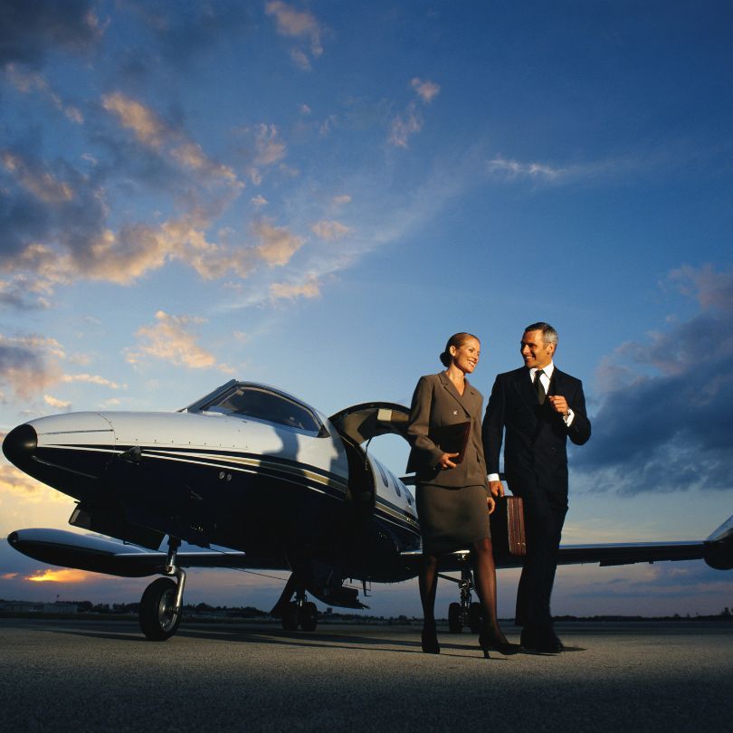 Man and woman on the ground ground   with a private jet